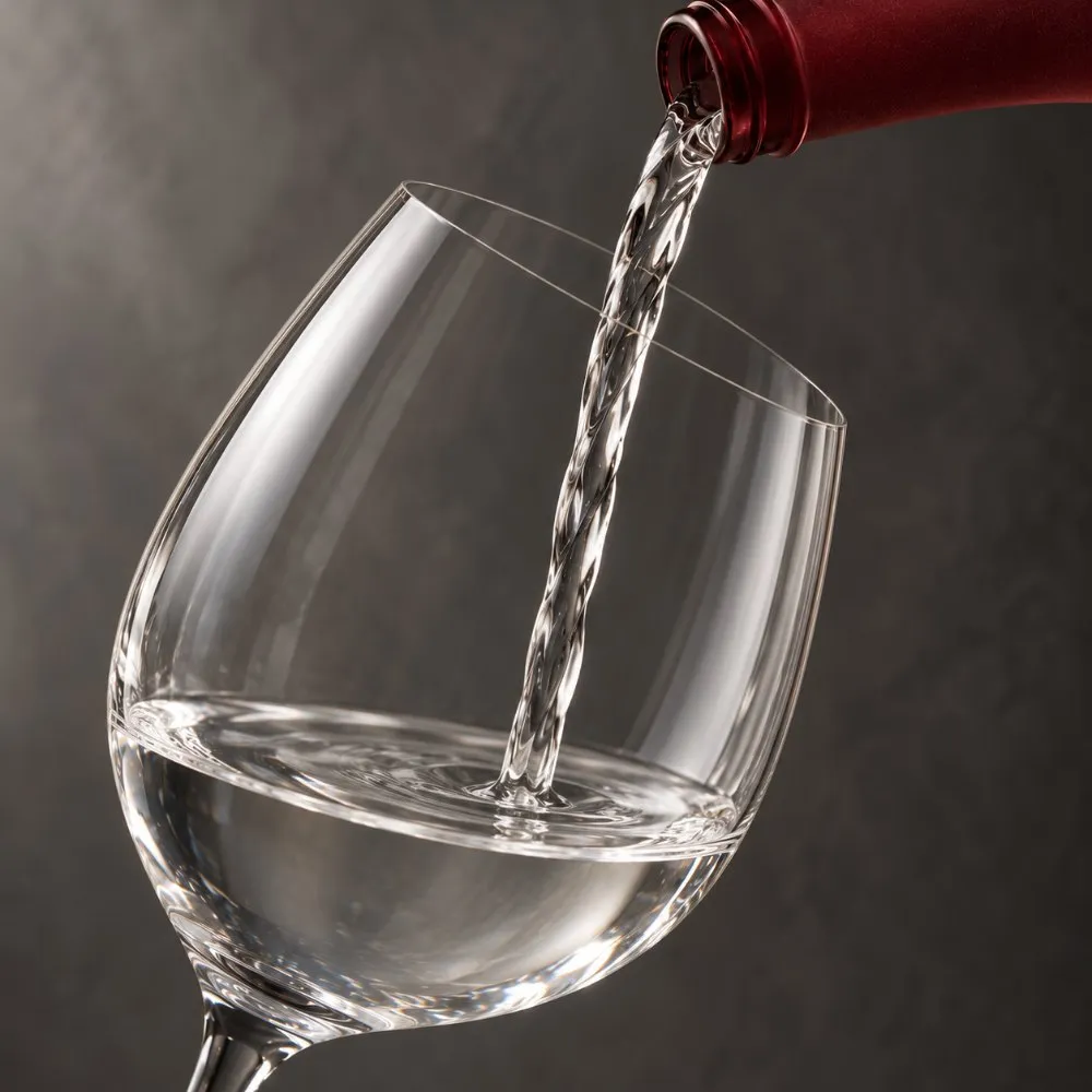 赤い煌菊のボトルからワイングラスに注がれる日本酒